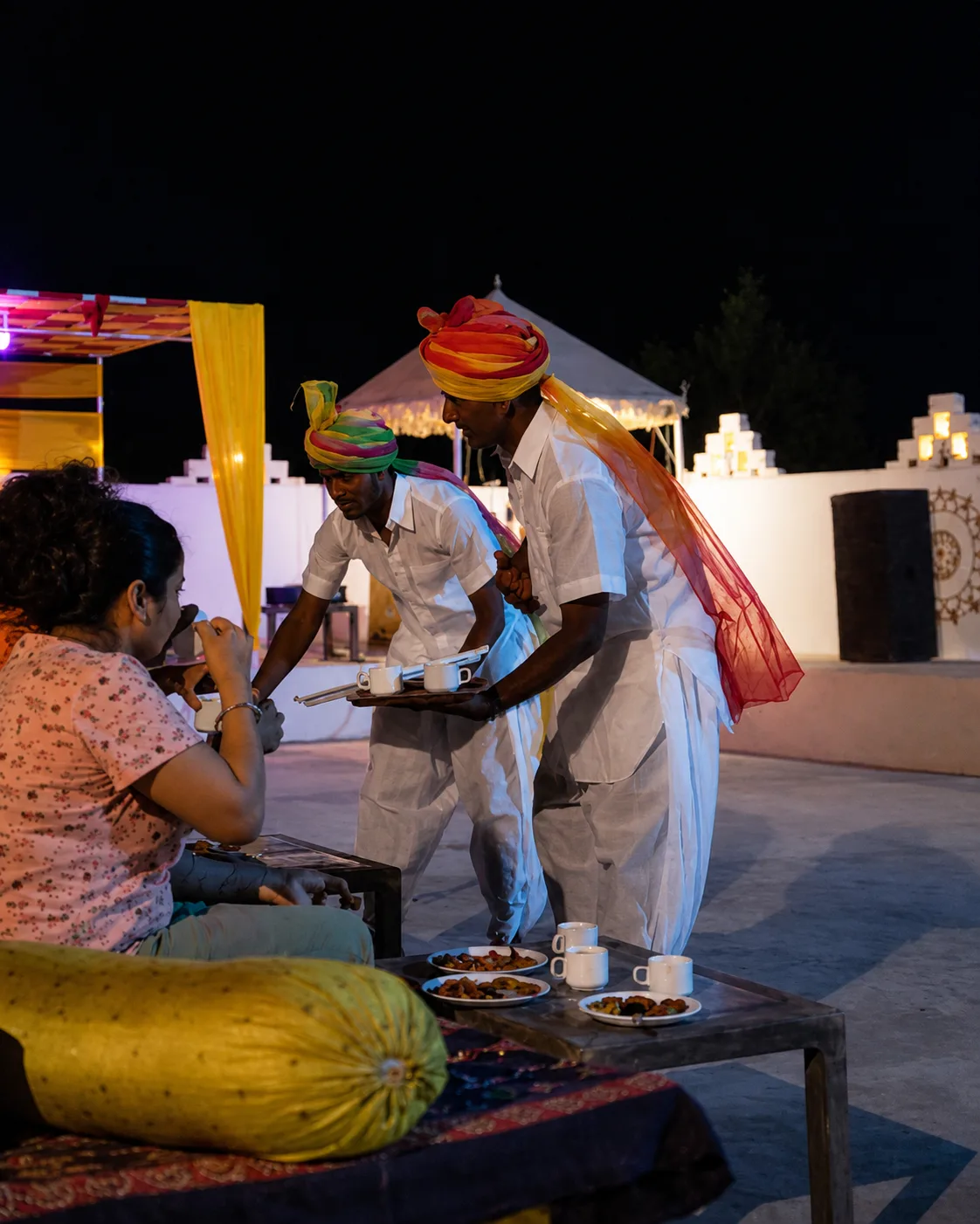 Sunny Desert Camp staff in traditional turbans serving evening tea and refreshments