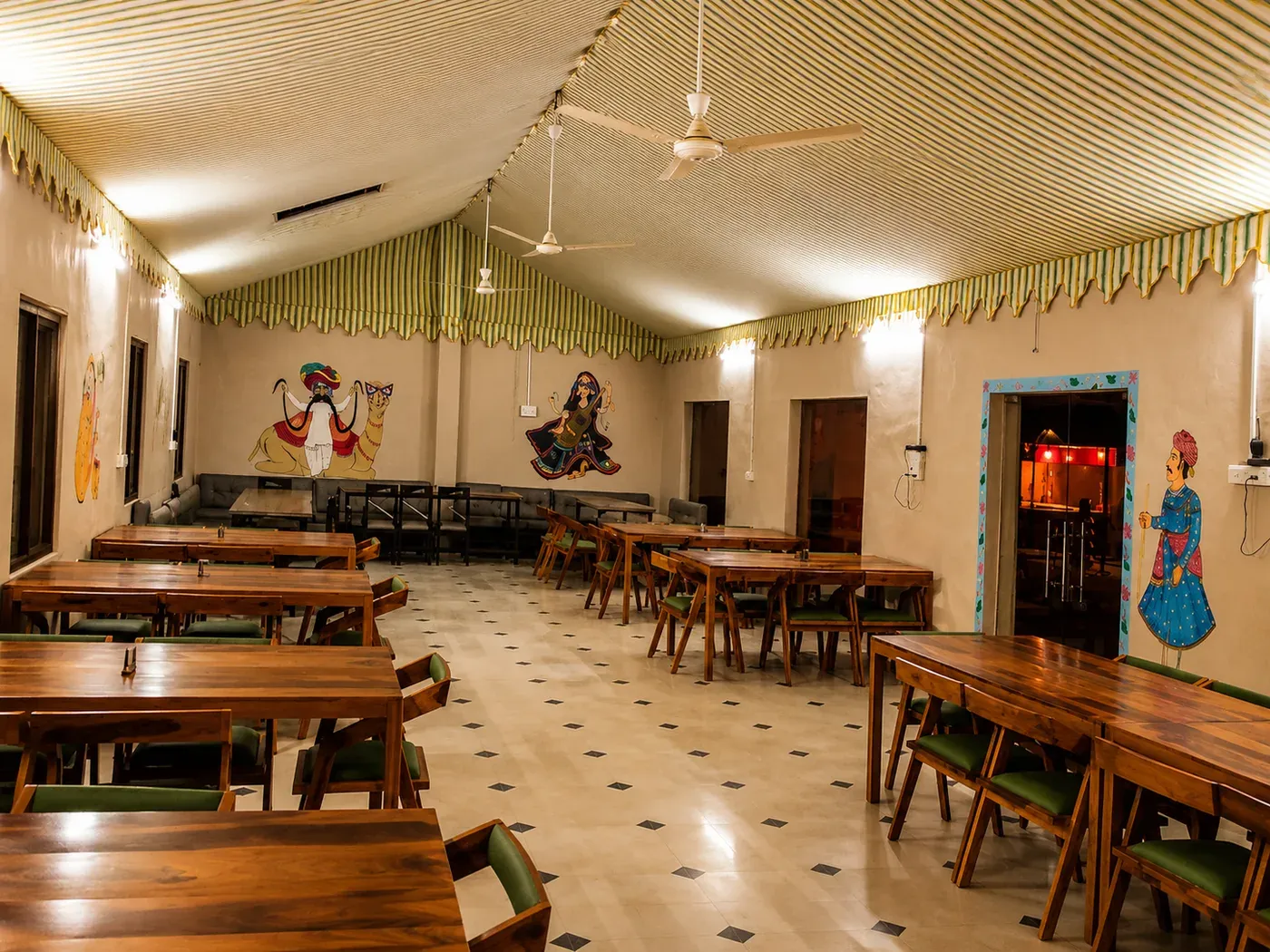 Dining hall tables and seating area with traditional Rajasthani artwork