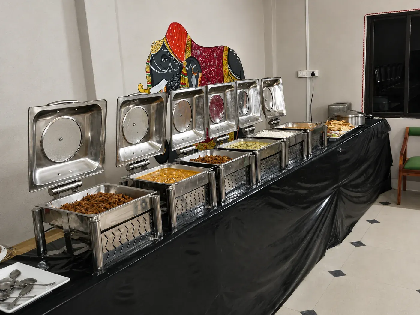 Buffet counter with stainless steel chafing dishes serving warm meals